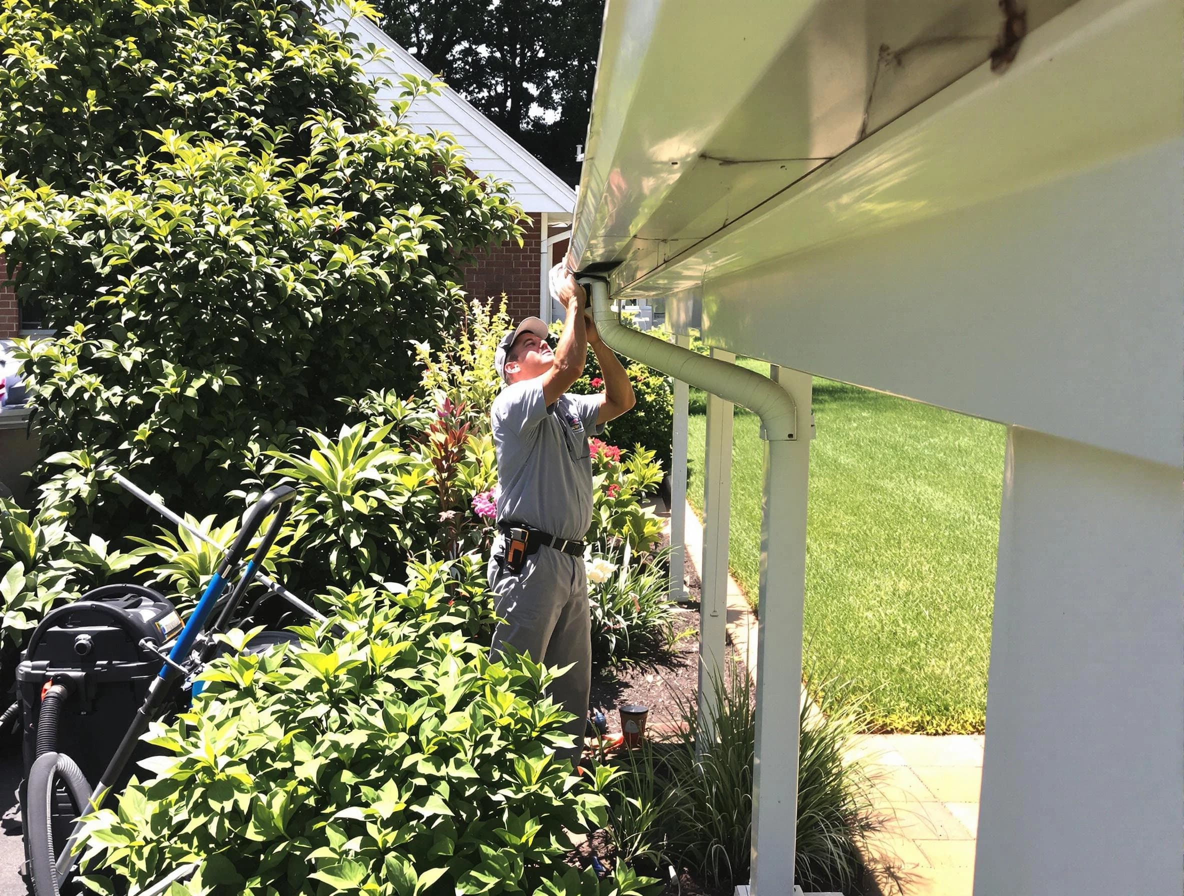 Technician flushing a blockage from a downspout in Lorain, OH